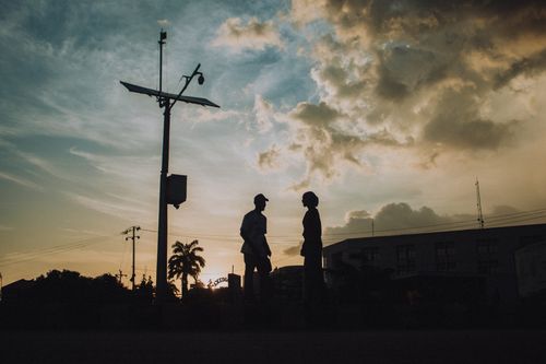 Free Silhouetted figures against a stunning sunset in Kaduna, capturing the urban landscape. Stock Photo