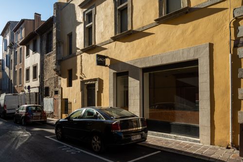 Free Sunlit street in Carcassonne with historic architecture and parked cars. Stock Photo
