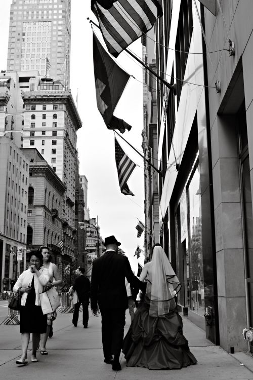 Free Black and white photo of a bride and groom on a bustling New York City street, capturing urban romance. Stock Photo