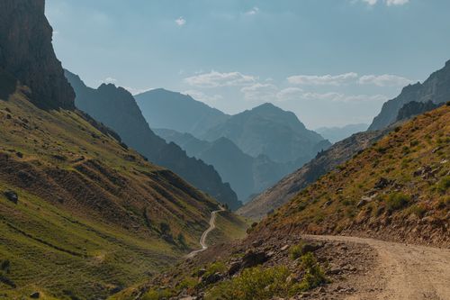 Free Breathtaking view of a winding road through a picturesque mountain landscape on a sunny day. Stock Photo