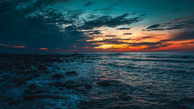 6594x3709 Desktop 自然风景 Wallpaper - 日落时分岩滩海岸 橙红晚霞与青蓝色海面形成强烈色彩对比