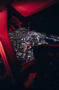 A breathtaking aerial night view of Toronto's skyline featuring the illuminated CN Tower.