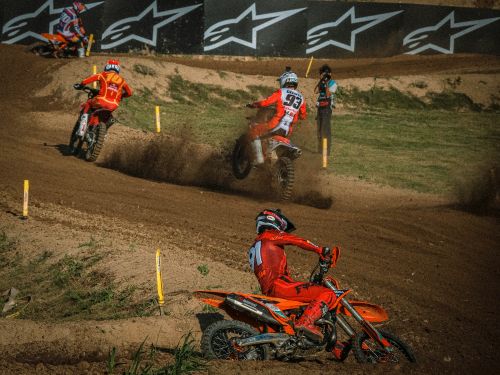 Free Exciting dirt bike race with riders navigating a challenging, muddy track outdoors. Stock Photo
