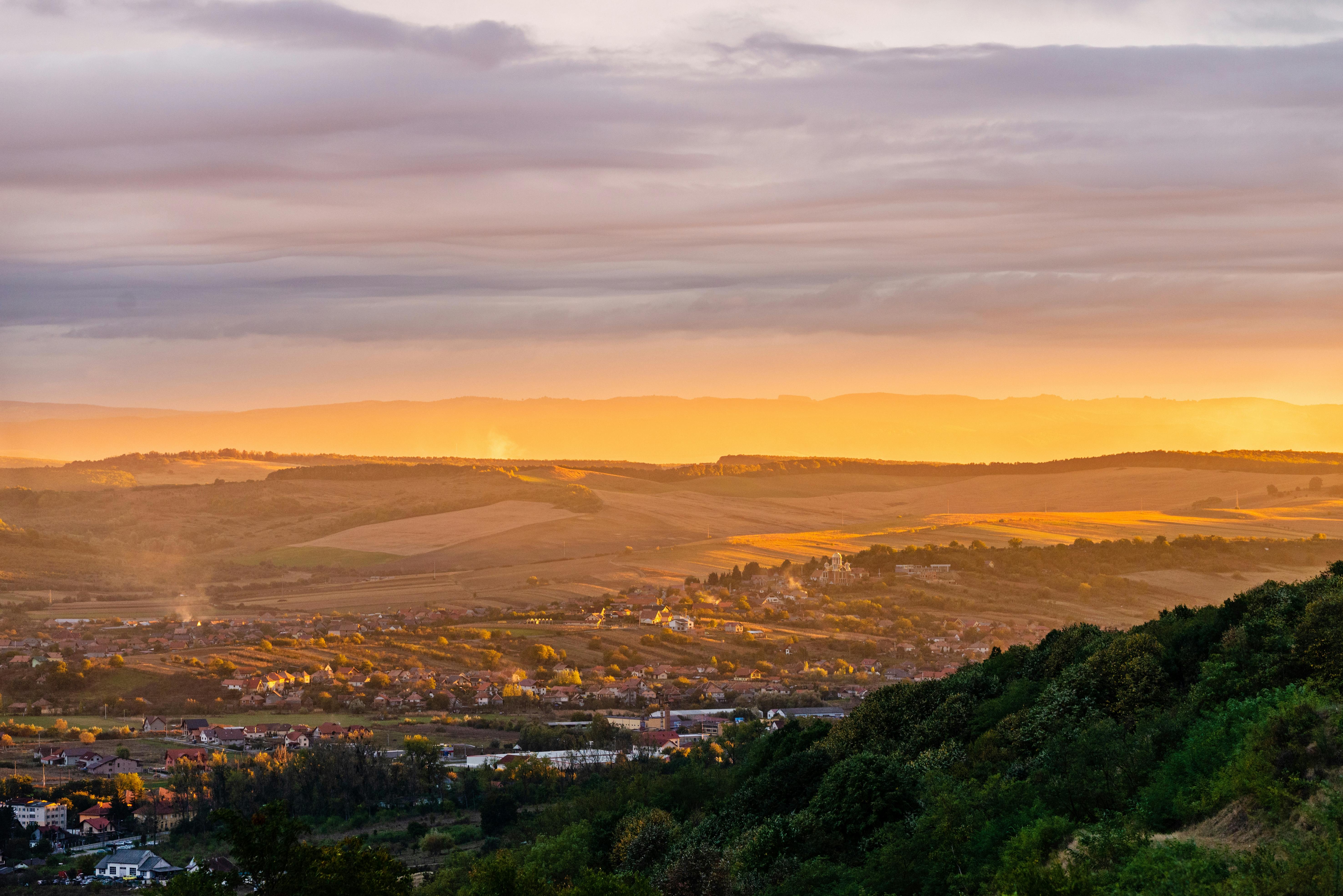 罗马尼亚的一个乡村村庄，金色的光线和起伏的山丘，构成了一幅令人惊叹的日出景象