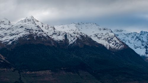Free Stunning snow-capped peaks of New Zealand's Southern Alps under a cloudy sky, captured in winter. Stock Photo