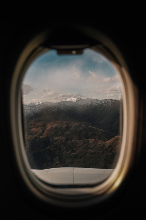 Free View of New Zealand mountains through an airplane window in daylight. Stock Photo