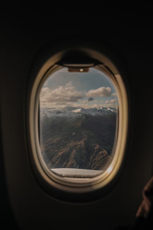 Free Captivating view of snowy New Zealand mountains through airplane window, showcasing natural beauty. Stock Photo