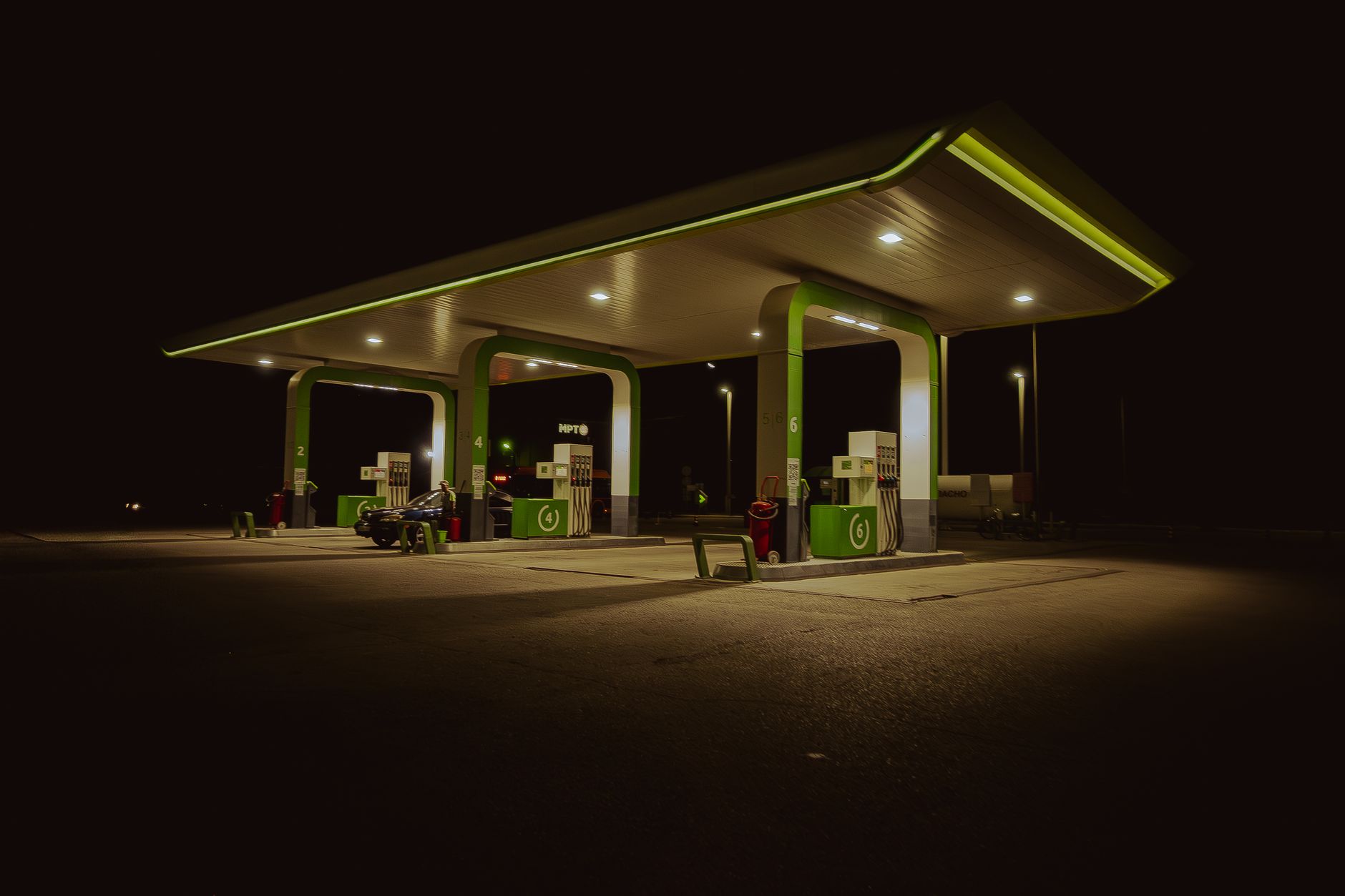 A modern gas station in Aktobe, Kazakhstan, brightly lit under the night sky.
