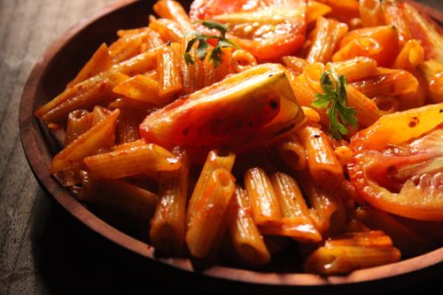 Free Close-up of flavorful penne pasta with fresh tomatoes and parsley garnish, ideal for Italian cuisine lovers. Stock Photo