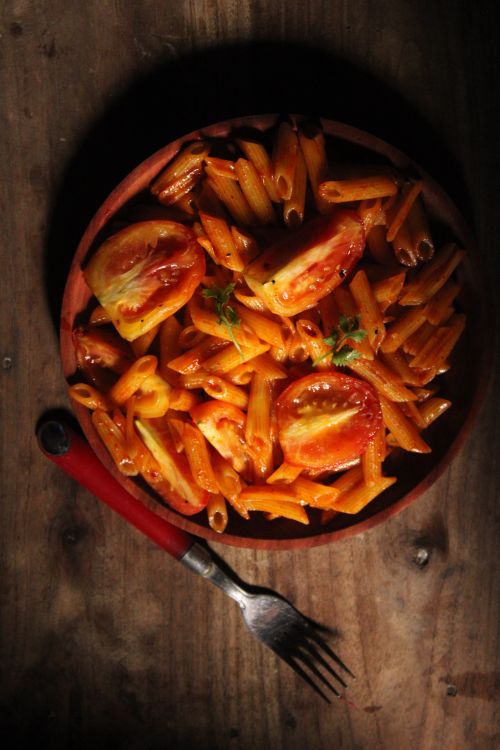 Free Top view of tomato penne pasta served on a wooden table with fork. Stock Photo
