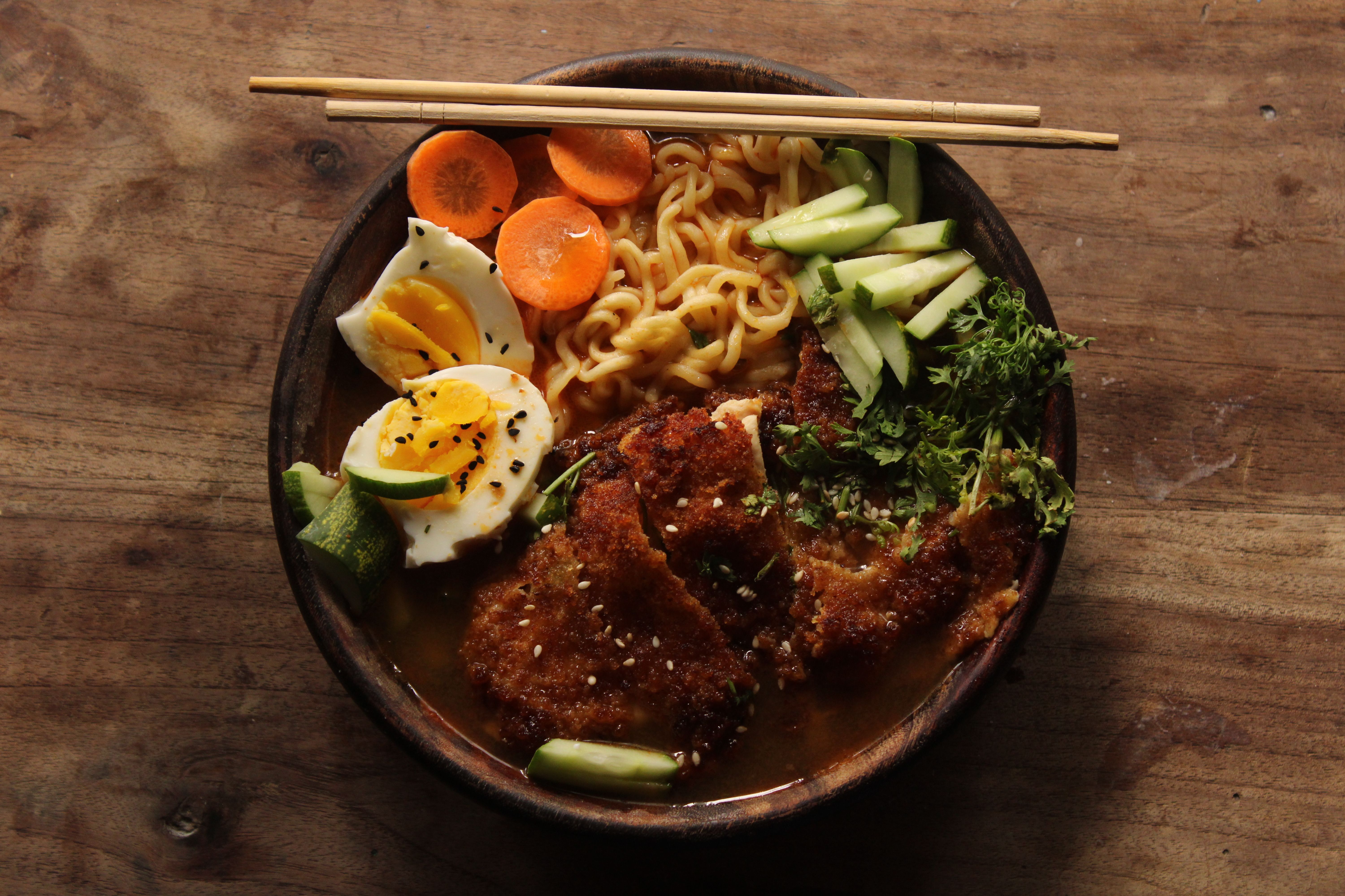 Close-up shot of a flavorful ramen bowl with egg, katsu, and fresh vegetables. - Photo by Jahra Tasfia Reza on Pexels