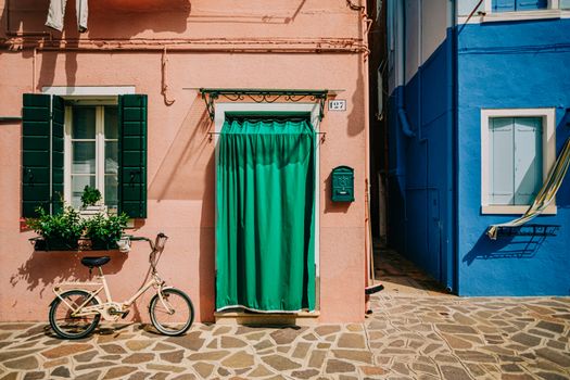 Charming vibrant street view with pastel walls, bicycle, and plants.