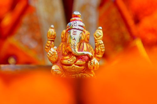 Free A detailed and vibrant depiction of a Lord Ganesha idol surrounded by warm colors, symbolizing peace and devotion. Stock Photo