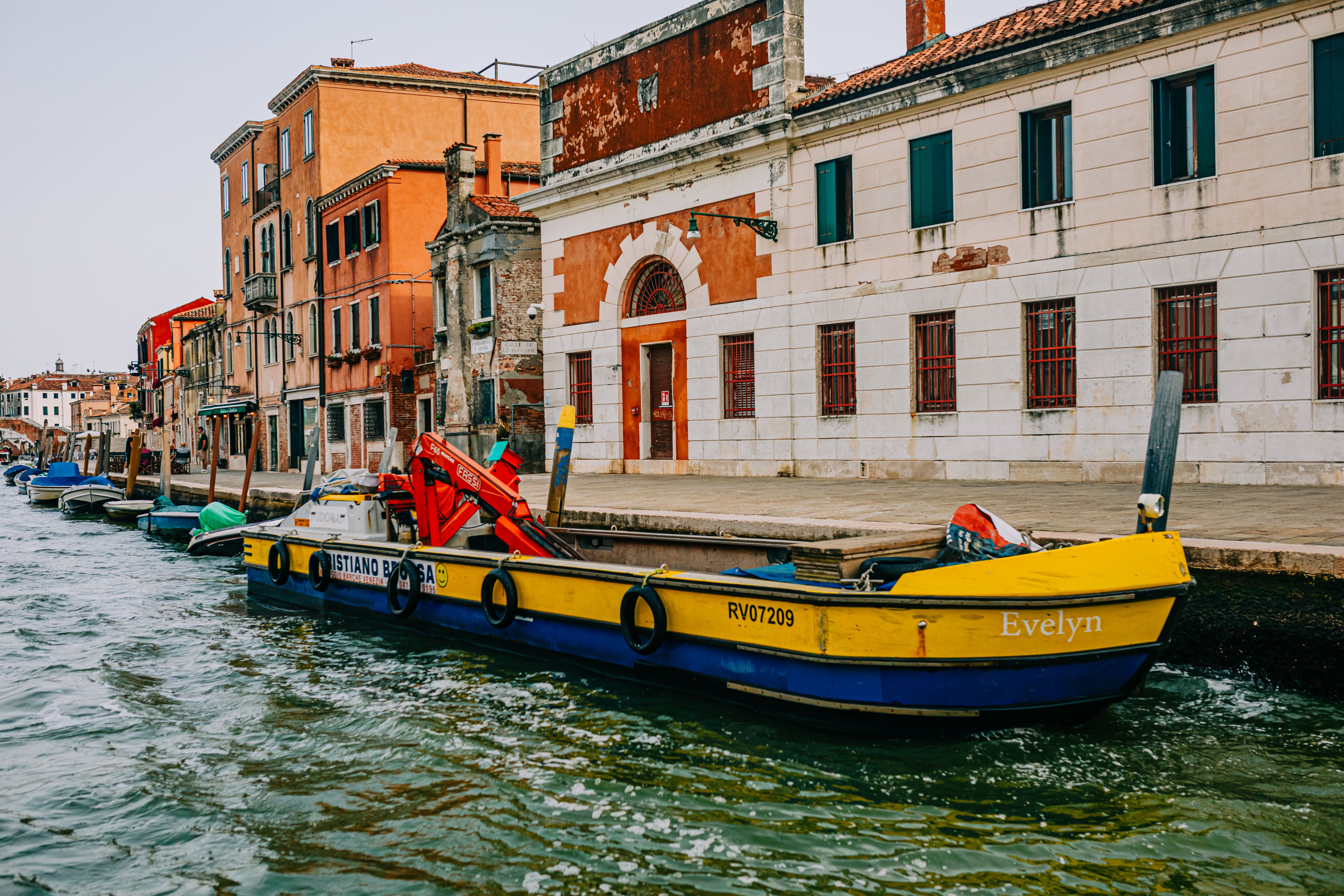 Vibrant scene of a Venetian canal with traditional architecture and colorful boats.