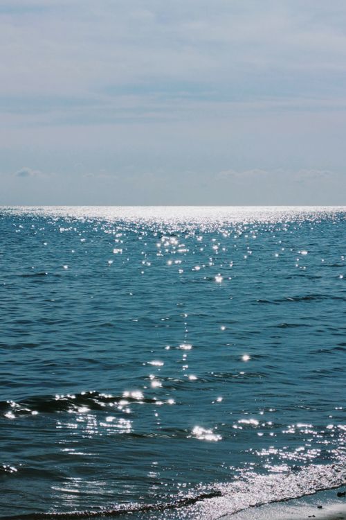 Free Serene ocean view with sunlight reflections on water under a clear blue sky. Stock Photo