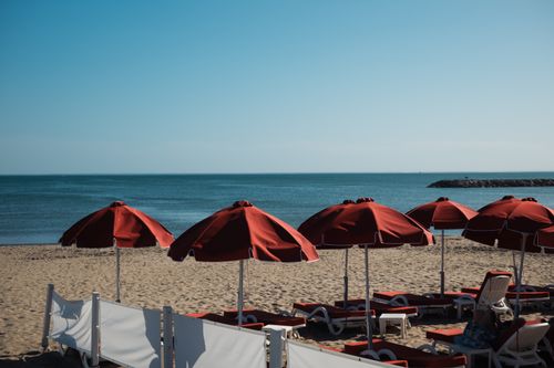 Free Scenic view of red parasols on La Grande-Motte beach, France, with the Mediterranean Sea. Stock Photo