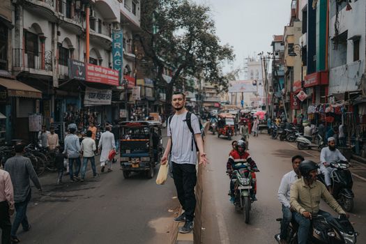 A lively scene captures the vibrant life of an Indian street, showcasing locals and travelers amidst lively traffic.