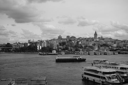 Free Black and white photo of Istanbul's waterfront with Galata Tower and boats on the Bosphorus. Stock Photo