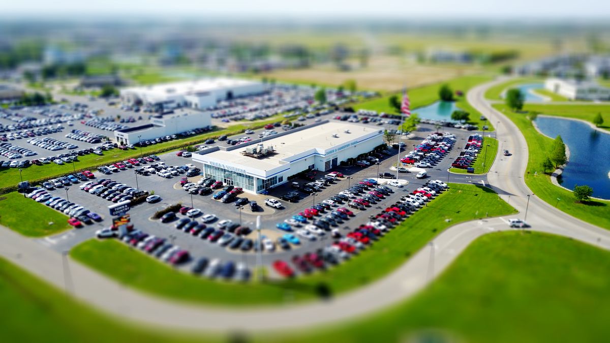 Aerial view of car dealership lot showing vehicle inventory and declining resale values