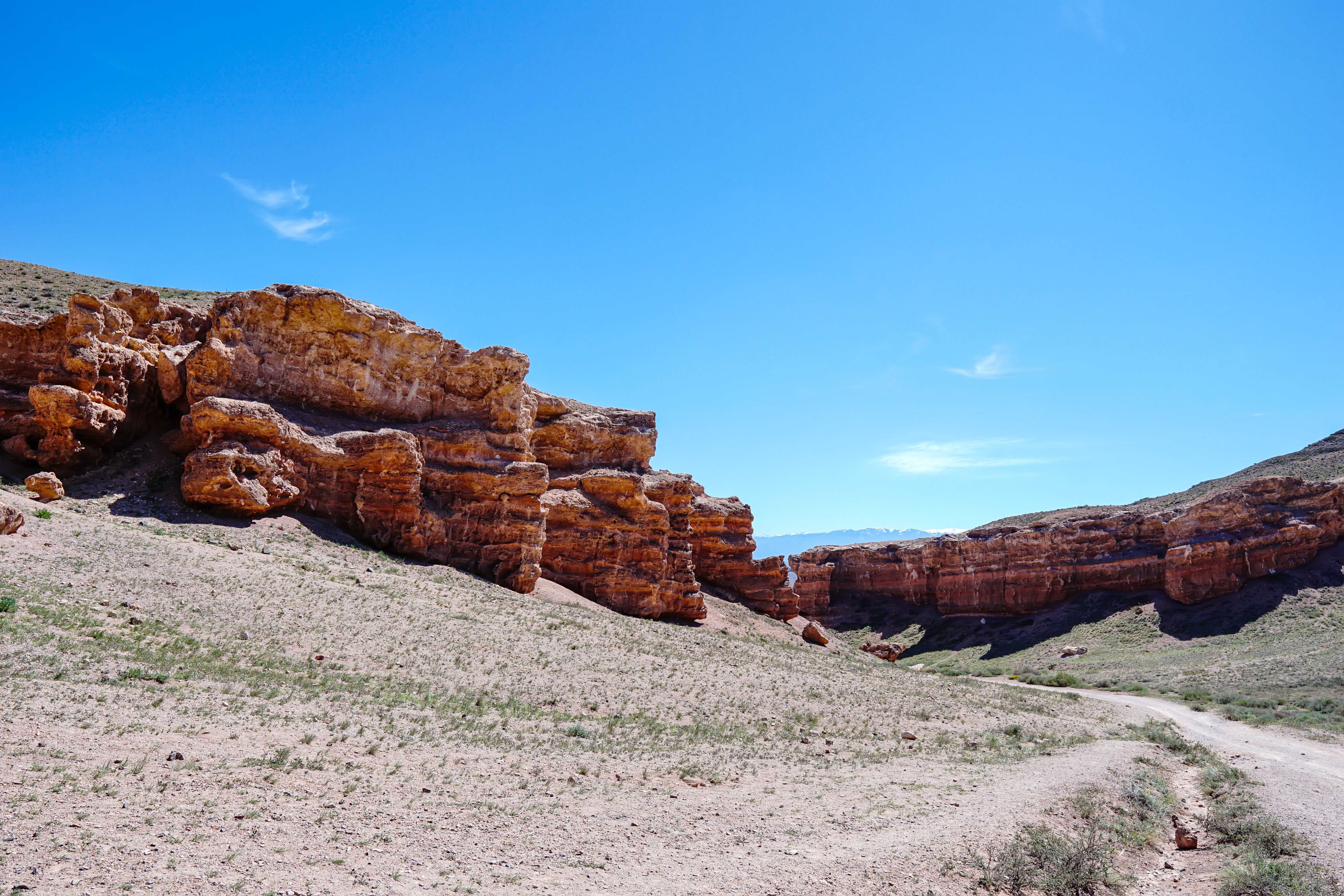 Explore the stunning rock formations of Charyn Canyon in Almaty Region, Kazakhstan under a clear blue sky.