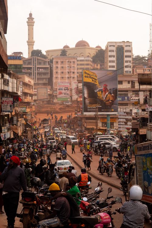Free Vibrant street life in Kampala, Uganda with motorbikes, cars, and pedestrians in a busy urban setting. Stock Photo