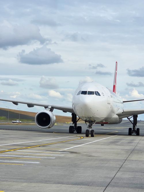 Free Large commercial airliner taxiing on the runway at an airport under a cloudy sky. Stock Photo