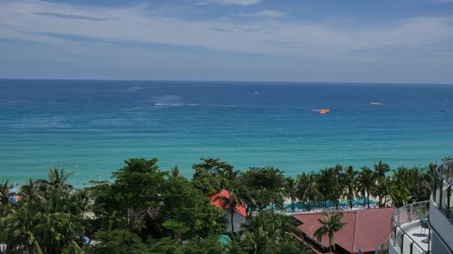 Free Sunny day view of the turquoise ocean and lush greenery in Sanya, Hainan, China. Stock Photo