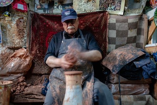 Free An artisan shaping pottery in a cozy Göreme workshop filled with cultural textures. Stock Photo