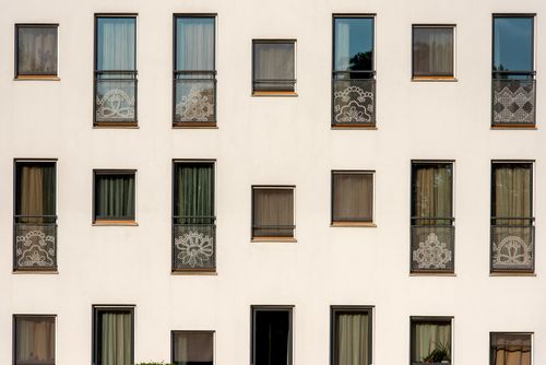 Free Contemporary apartment building facade with decorative balcony designs and symmetrically aligned windows. Stock Photo