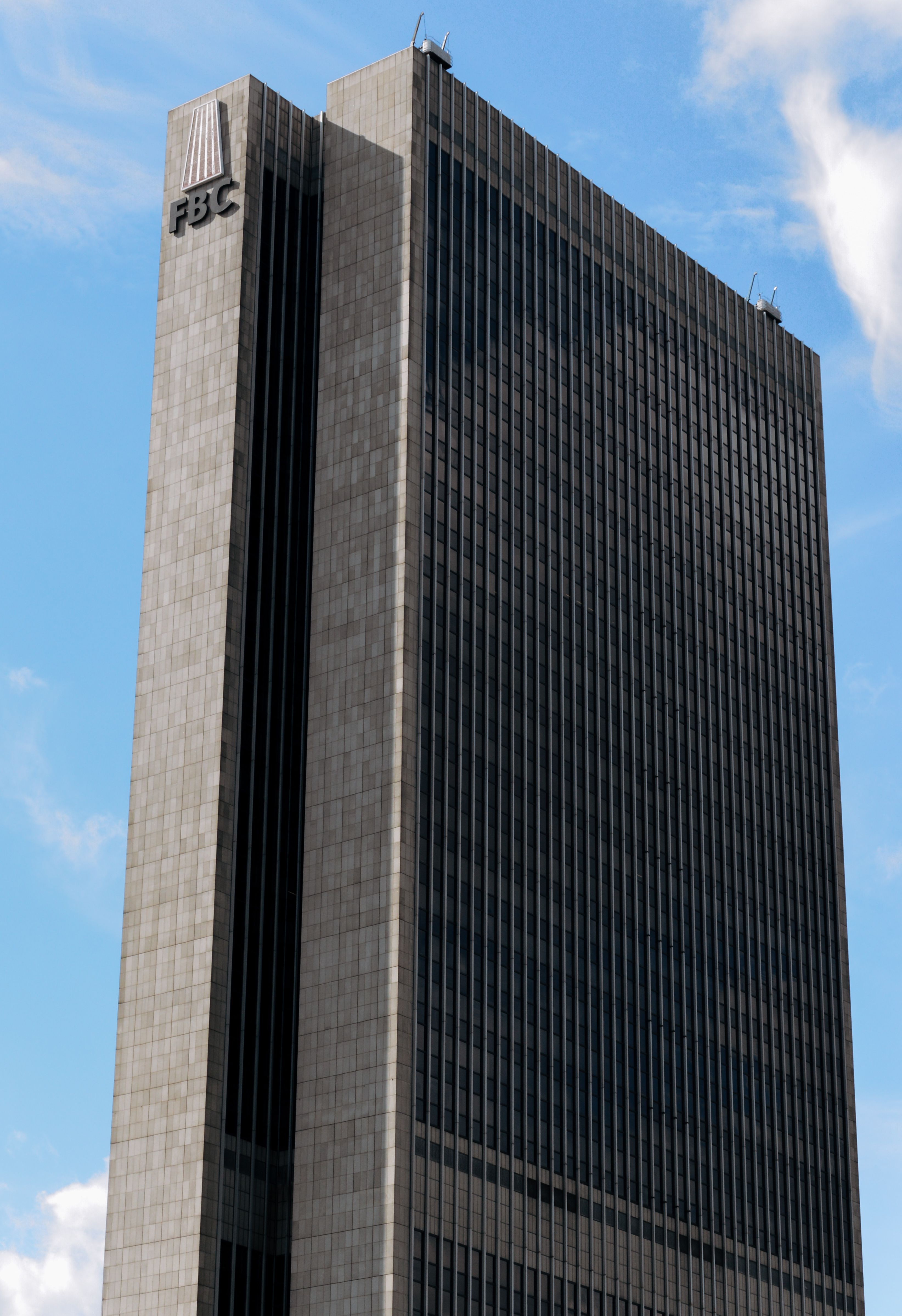 Tall skyscraper against blue sky in Frankfurt, showcasing modern architecture.