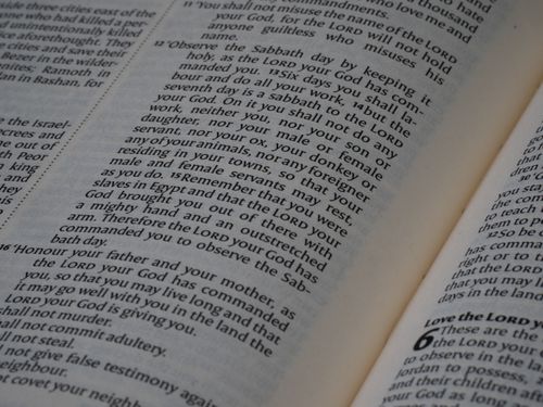 Free Close-up of an open Bible showing text from the Book of Deuteronomy, emphasizing scripture. Stock Photo