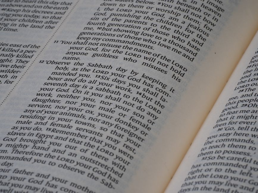 Detailed close-up of text from the Book of Deuteronomy in the Bible, focused on scripture reading.