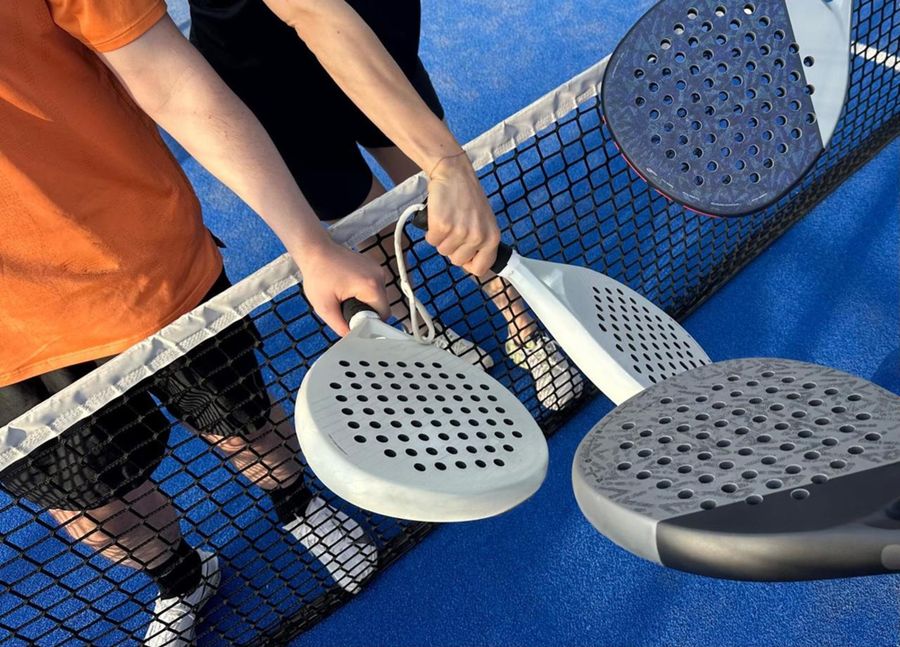 Two players touch rackets over the net after a match