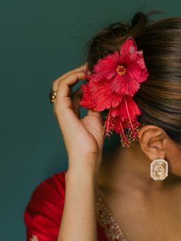 特写镜头：一位身穿红色连衣裙、头戴芙蓉花发饰的女子。 - 相关推荐