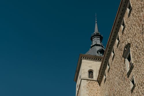 Free Elegant stone tower in Toledo, Spain with a clear blue sky. Perfect for travel and architecture lovers. Stock Photo