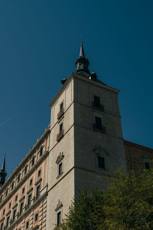 Free View of the historic Alcázar tower in Toledo, showcasing its iconic architecture against a clear sky. Stock Photo