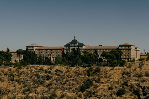Free Panoramic view of a historic building with trees in Toledo, Spain. Stock Photo