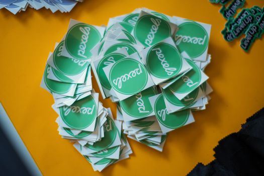 A collection of green Pexels stickers neatly stacked on a vibrant yellow background.