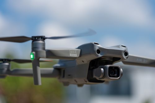 Free Close-up of a drone flying outdoors, highlighting its camera and technology against a blue sky. Stock Photo