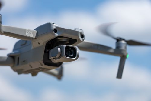 Free Close-up of a modern drone in flight against a blue sky, showcasing advanced technology. Stock Photo