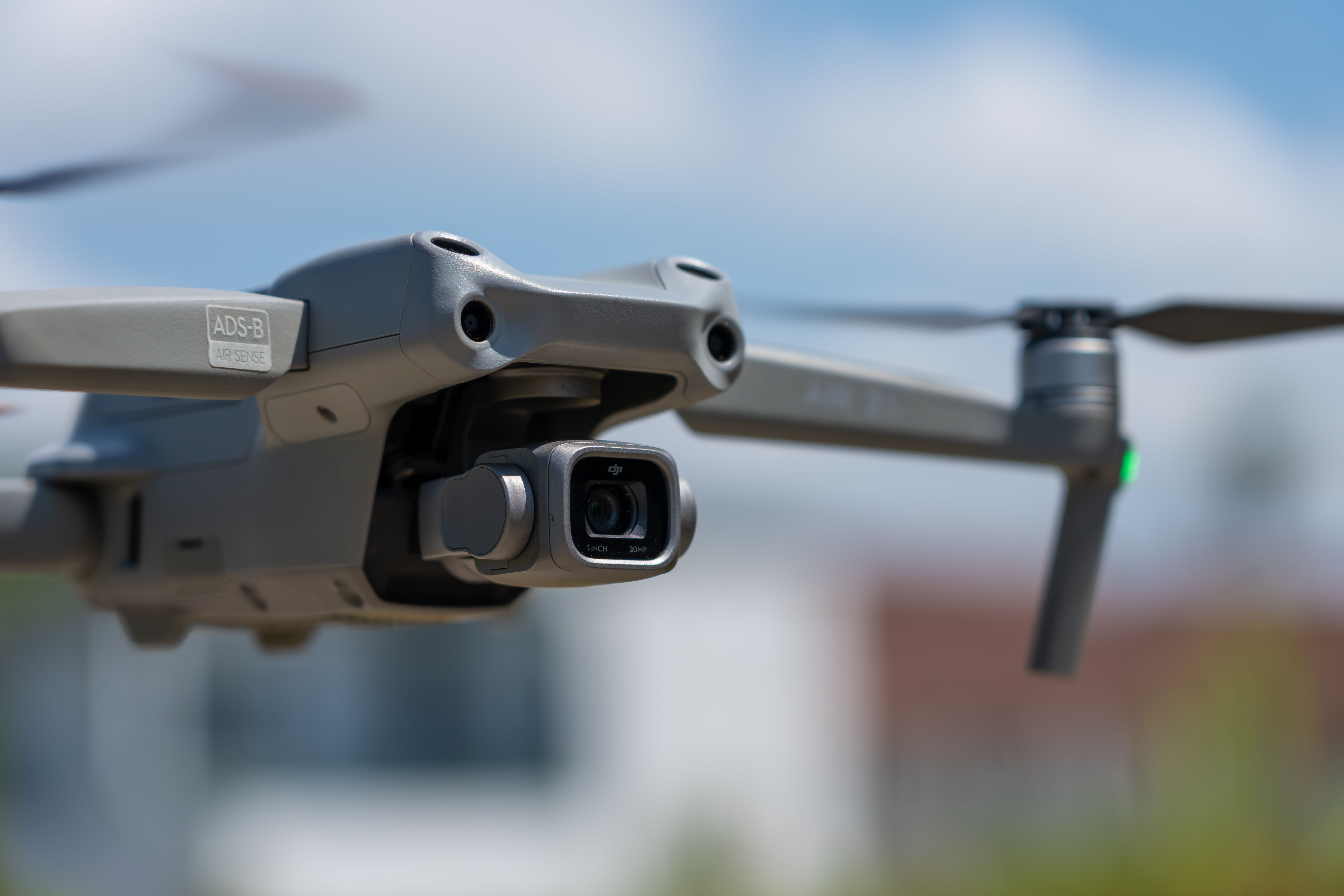 Detailed close-up of a drone in flight with camera set against a clear blue sky.