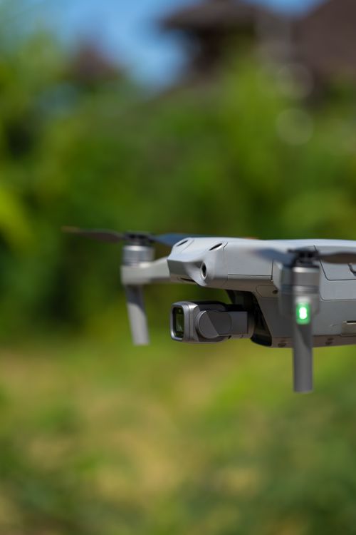 Free A drone in flight against a vibrant green outdoor backdrop, showcasing modern technology. Stock Photo