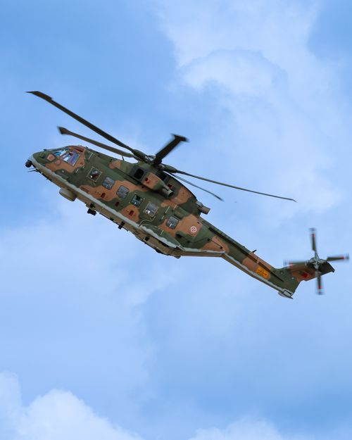 Free A military helicopter flying in a clear blue sky, showcasing aviation prowess and technology. Stock Photo