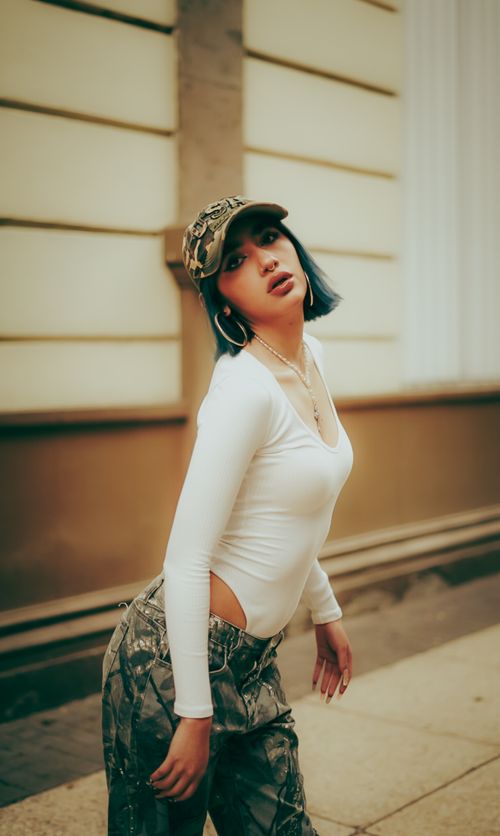 Free Stylish young adult posing in urban area with a casual outfit, expressing modern street style. Stock Photo