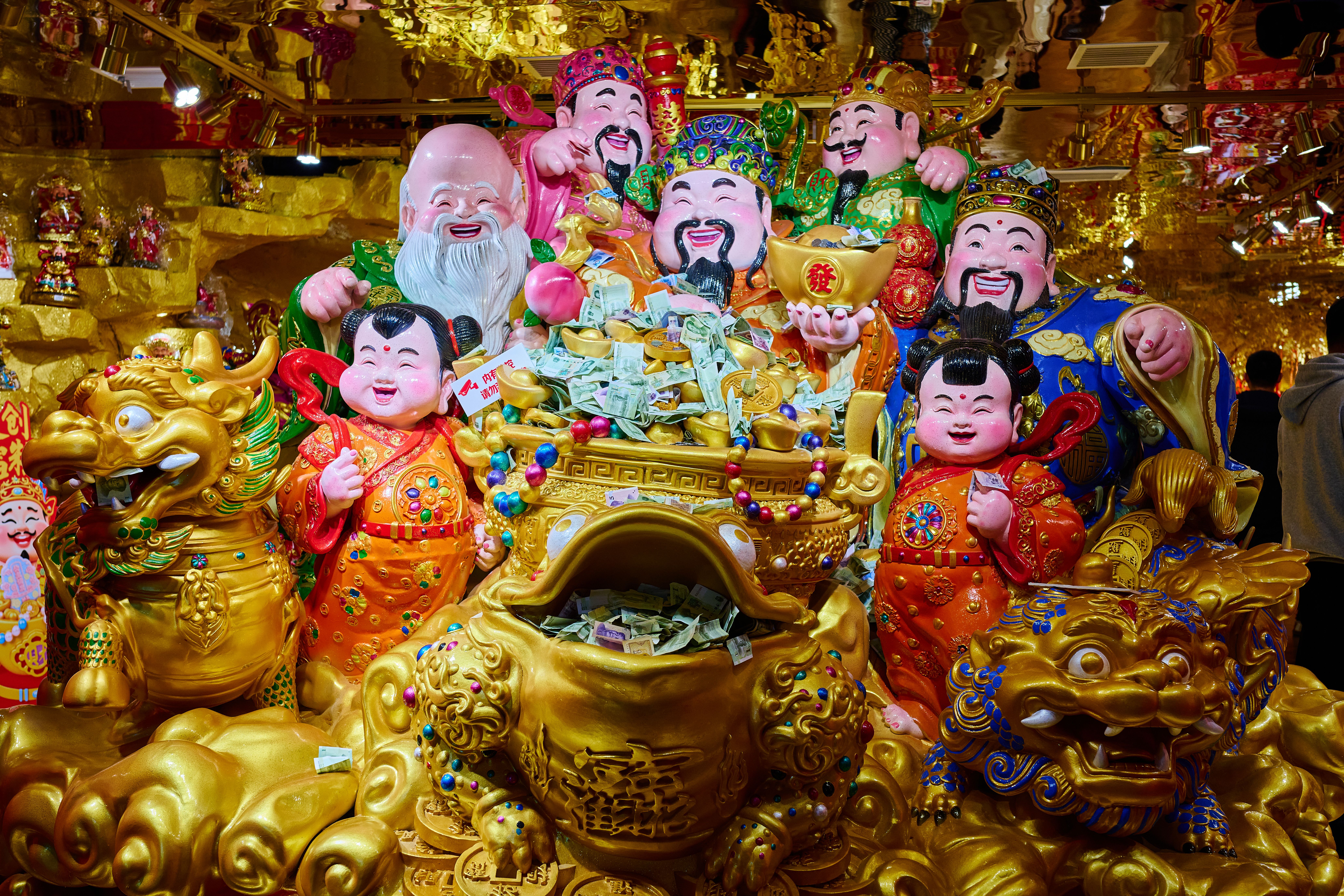 Vibrant feng shui figurines and gold decorations in a traditional setup showcasing wealth symbols.