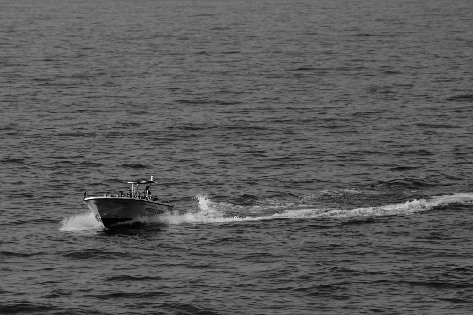 Bateau de pêche et de plongée glissant sur la mer, près de Ribadeo, en noir et blanc