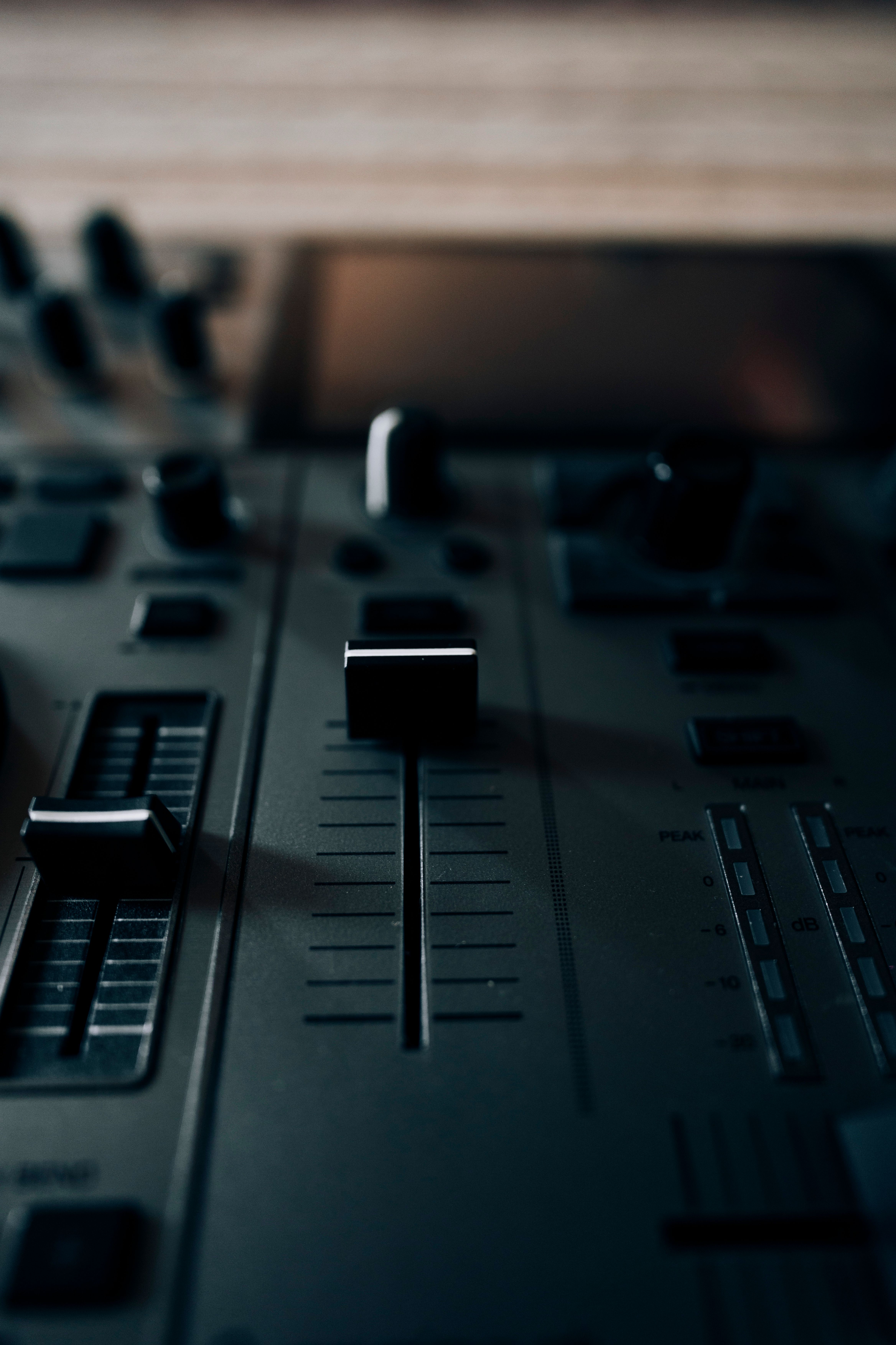 An artistic shot of a DJ mixer console with sliders, perfect for music themes.