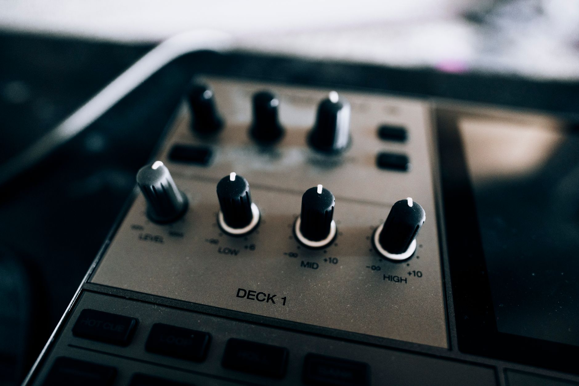 Uma visão aproximada de um mixer de DJ, mostrando seus botões e controles.
