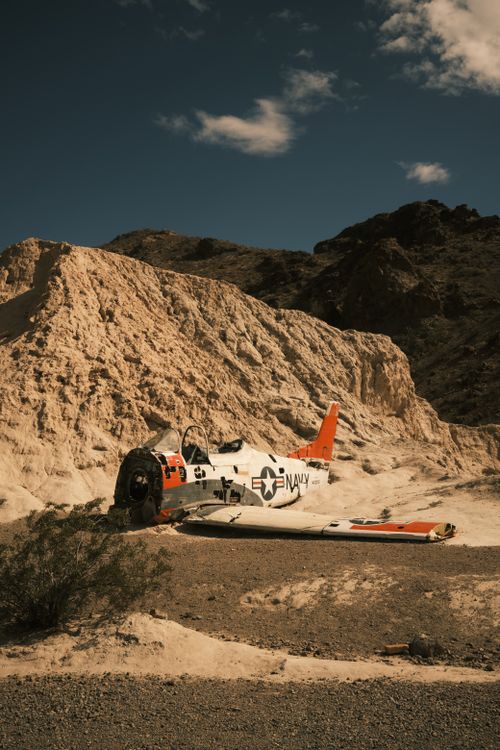 Free A vintage Navy jet wreckage lies in the Nevada desert landscape under a clear sky. Stock Photo