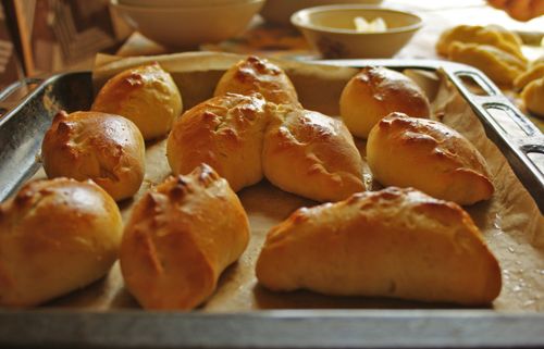 Free Golden brown homemade bread rolls fresh from the oven on a baking tray, showcasing home baking. Stock Photo